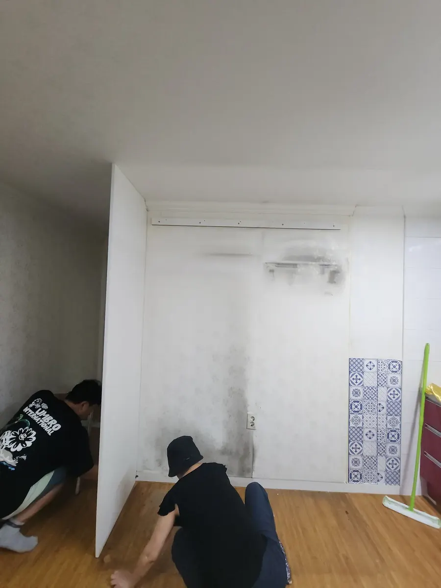 냉장고빌트인장 철거 — 바닥 쪽 고정을 푸는 작업자